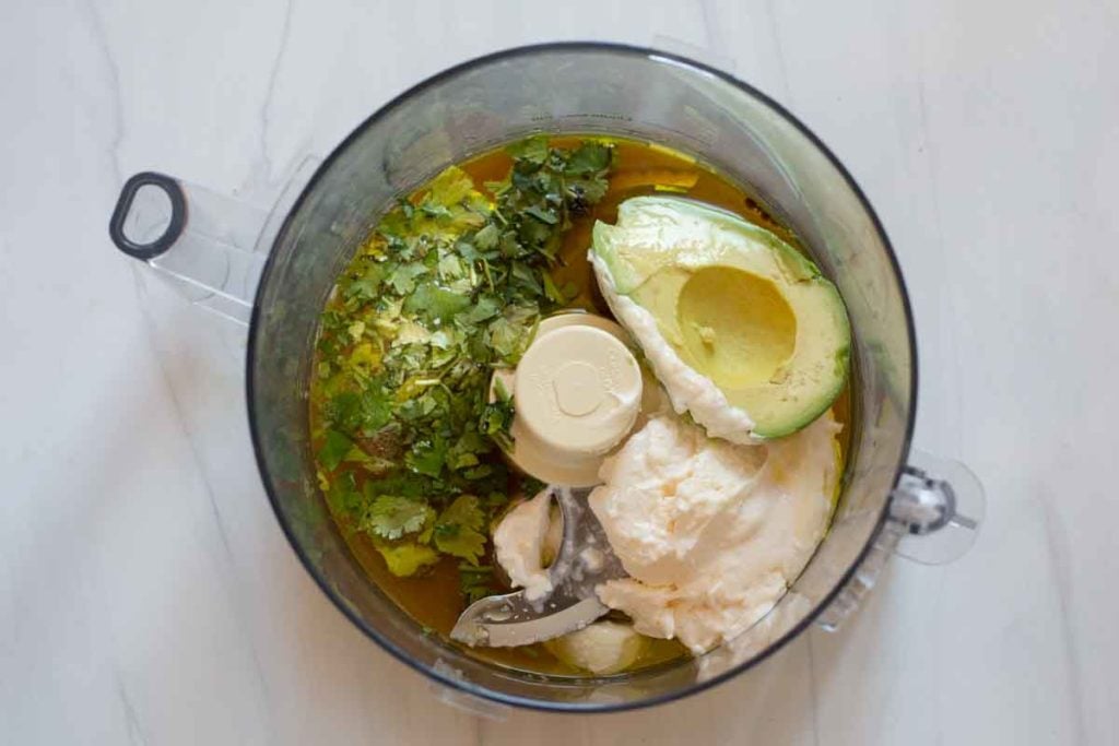 Using a food processor to blend avocado mayonnaise lime sauce