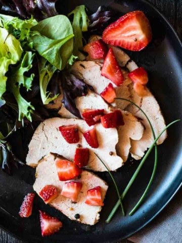 Pickled strawberries served over sliced pork roast.