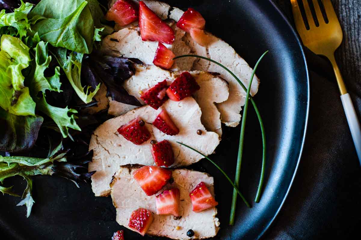 Grilled pork loin roast topped with strawberries and served with a side salad
