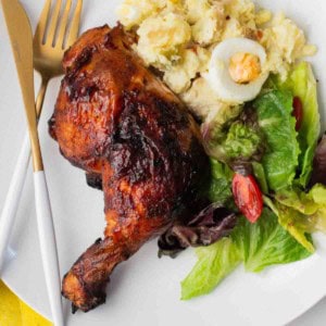 Grilled chicken halves served with potato and a salad.