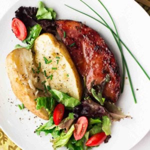 Grilled ham steak served with a salad and baked potato.