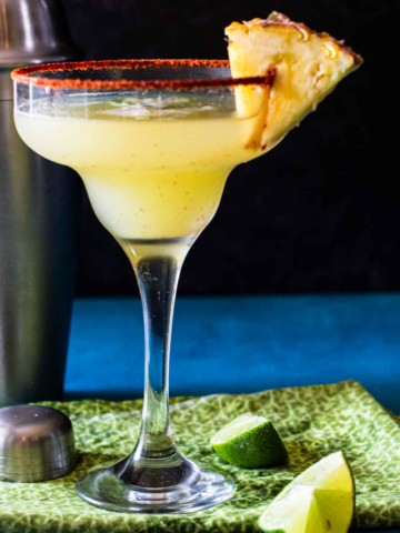 Pineapple Jalapeno Margarita garnished with chile powder and a wedge of fresh pineapple