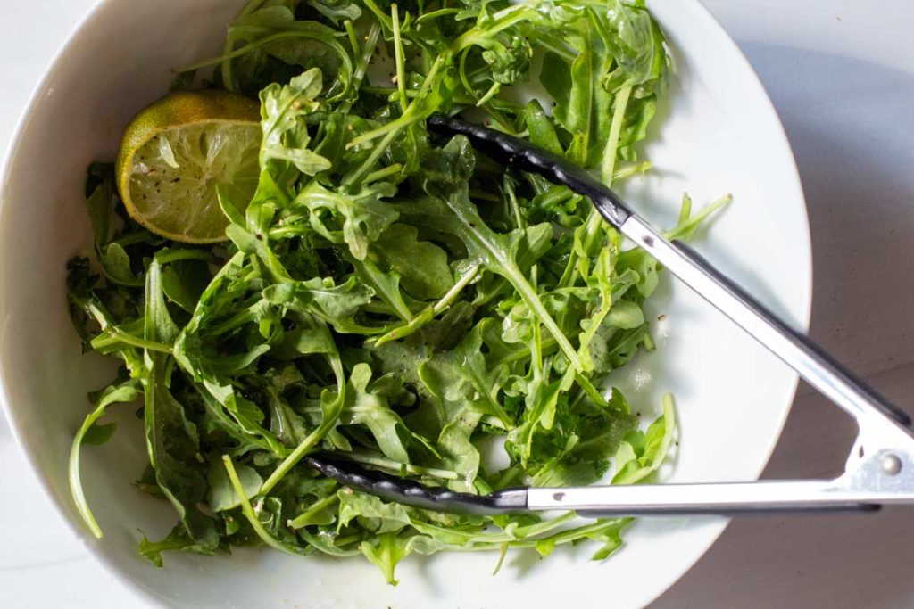 simple arugula salad dressed with lime juice and olive oil