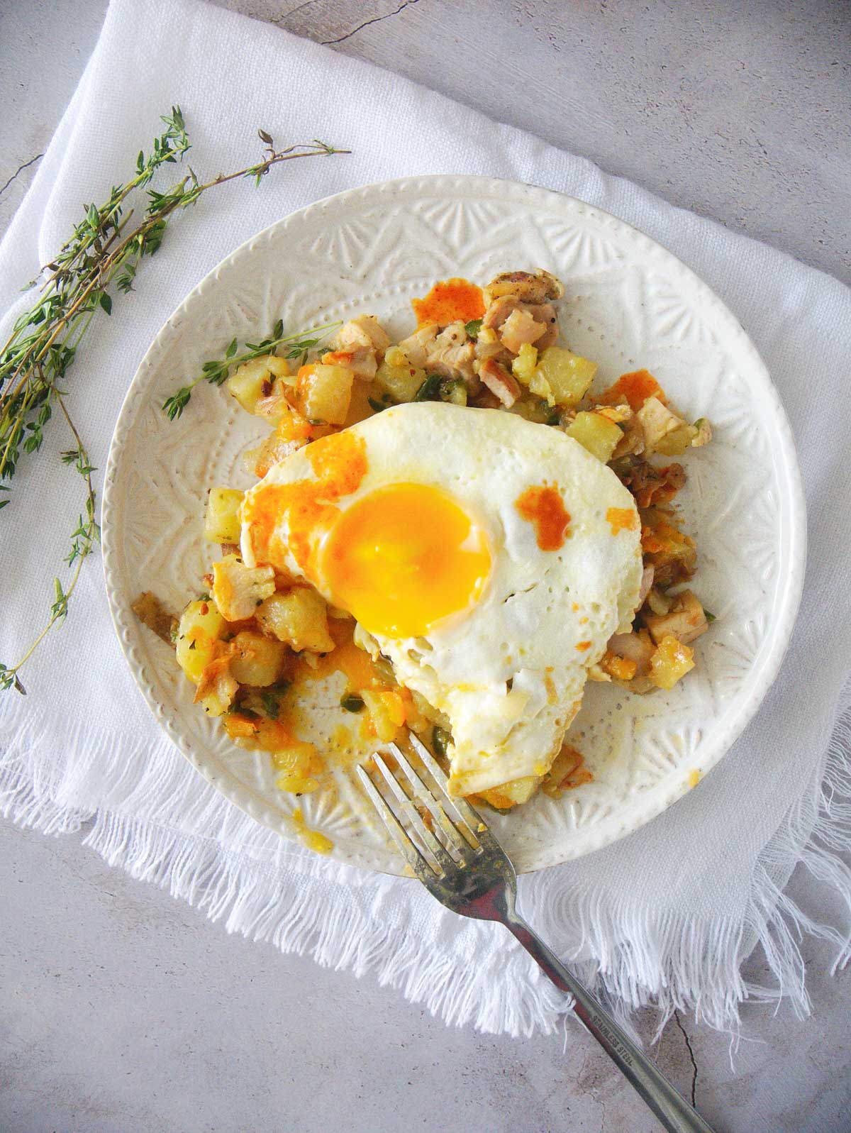 Chicken hash topped with a fried egg and a dash of hot sauce.