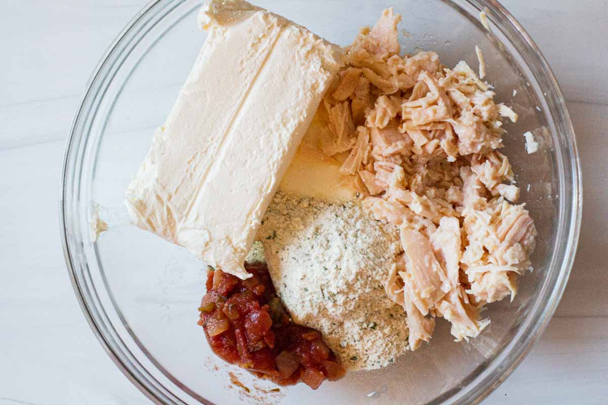 Ingredients to make chicken ranch dip in a bowl ready to be mixed together.