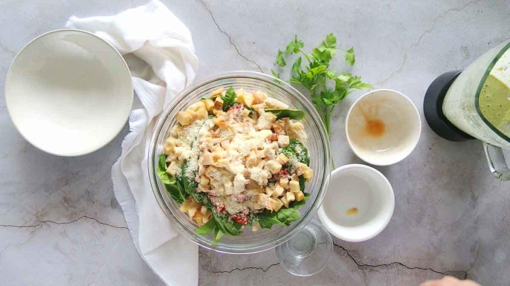 Adding cheese to cooked penne pasta to make pasta salad.