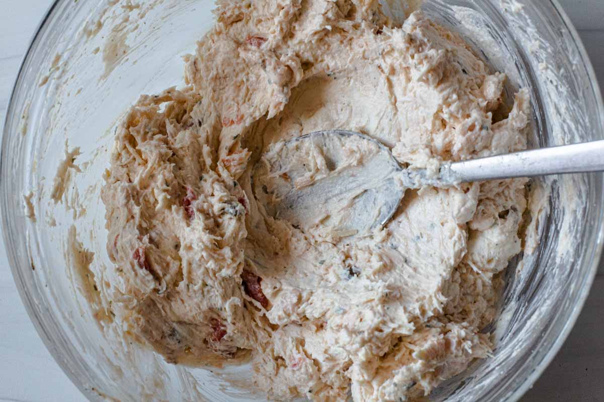Mixing chicken ranch dip to a smooth texture in a large bowl.