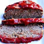 Old fashioned meatloaf on a white platter and sliced.