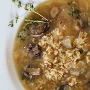 Brown rice mushroom soup without cream garnished with fresh thyme.
