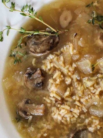 Brown rice mushroom soup without cream garnished with fresh thyme.