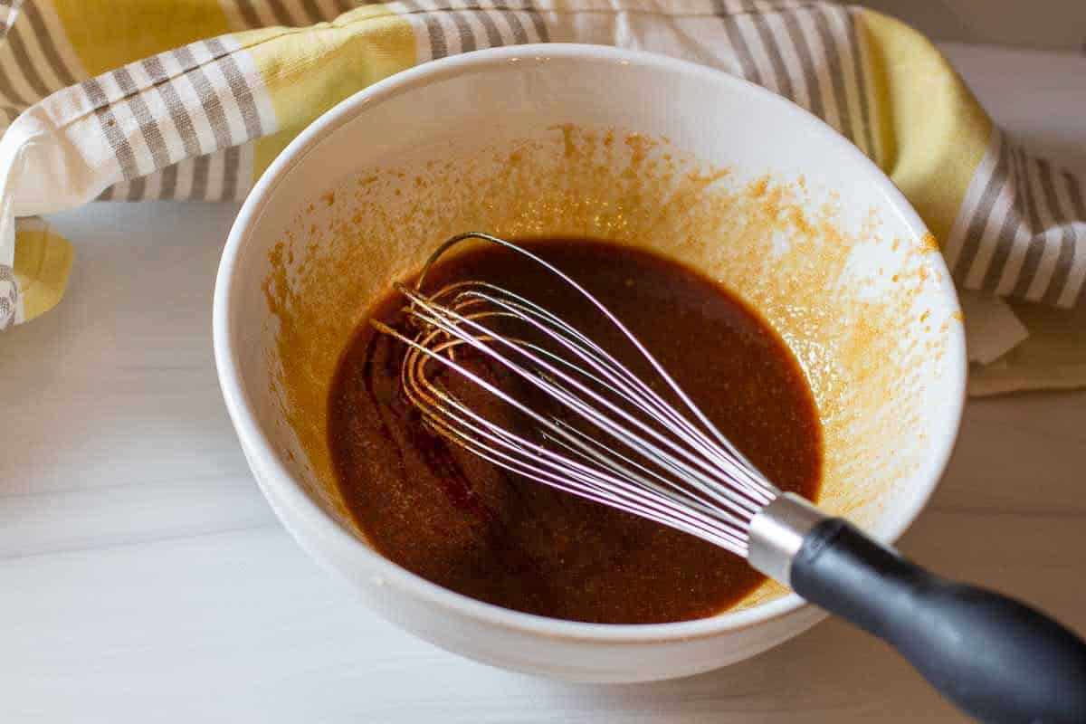Mixing soy sauce to make brown sugar green beans with bacon.