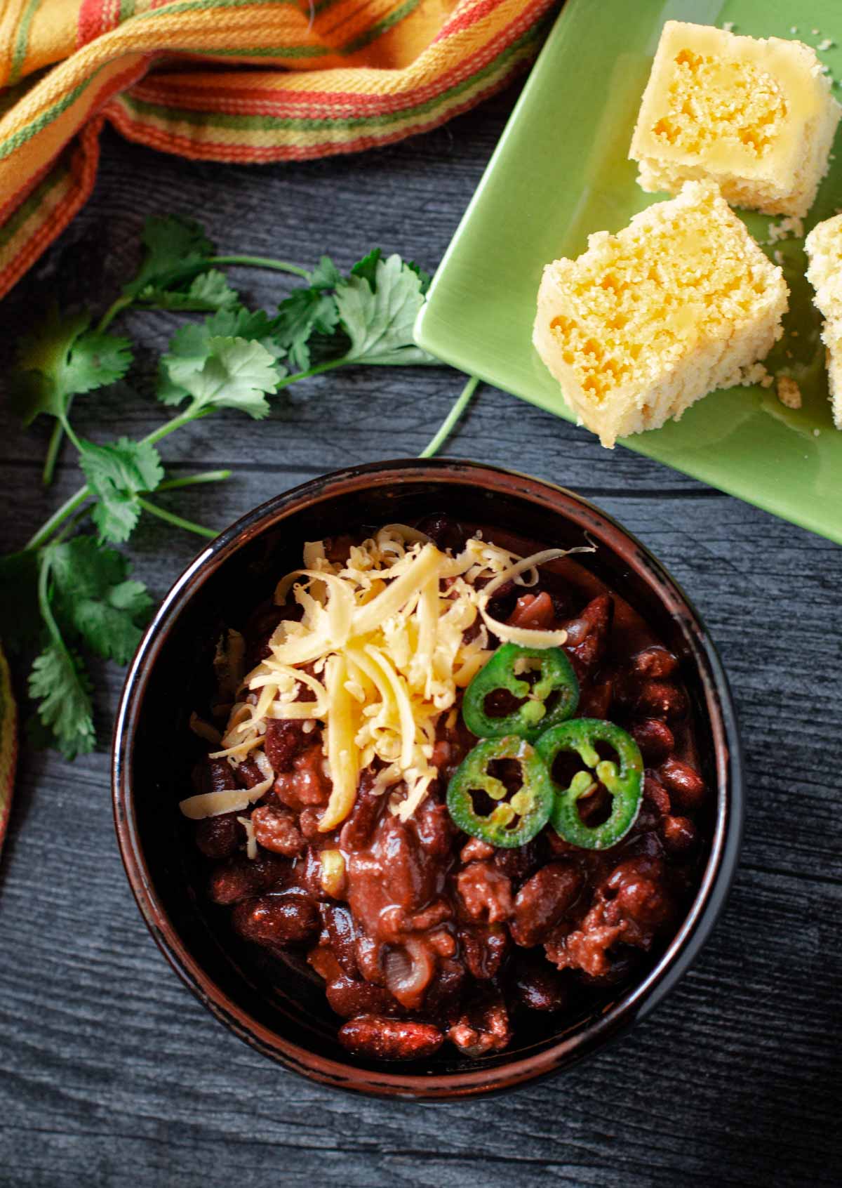 Cowboy chili topped with sliced jalapenos and grated cheddar cheese