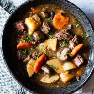 Beef stew with mushrooms served in a skillet.