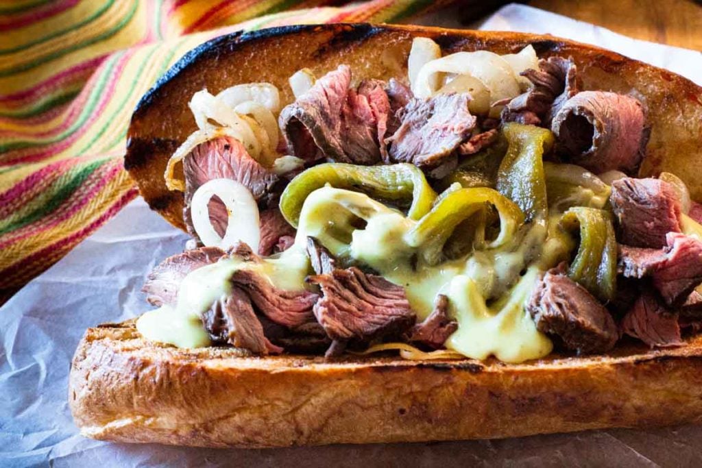 Bison steak sandwich with chile peppers, onions and queso blanco