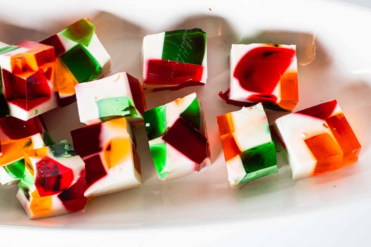 Cubes of Gelatin con tres leches in a white serving bowl.