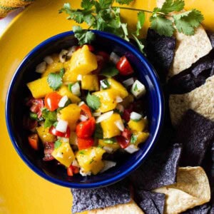 Mango Pico de gallo in a blue Fiesta bowl served with corn chips.