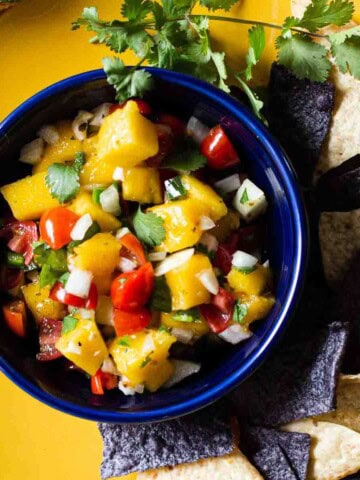 Mango Pico de gallo in a blue Fiesta bowl served with corn chips.