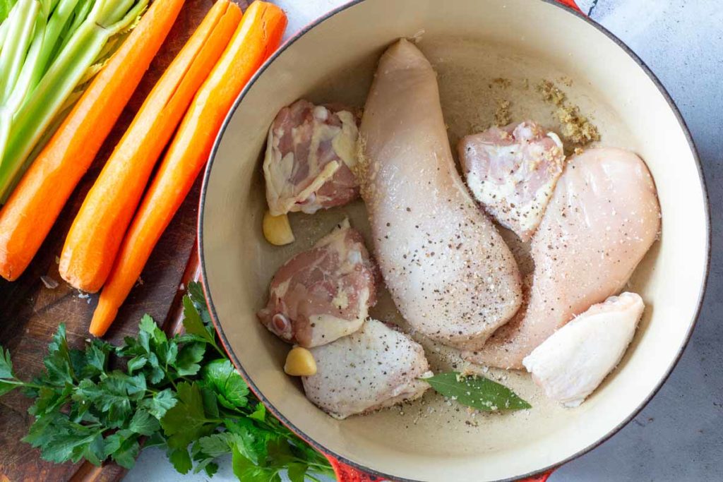 Cooking chicken in Dutch oven for lemon ginger chicken soup.