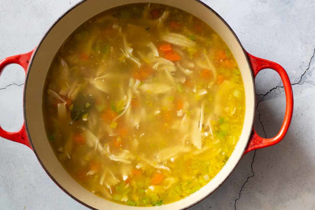 Lemon Ginger Chicken Soup in a Red Le Creuset Dutch Oven.