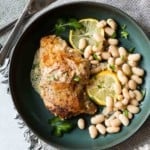 Pan fried chicken thighs served with lemon cream sauce and white beans.