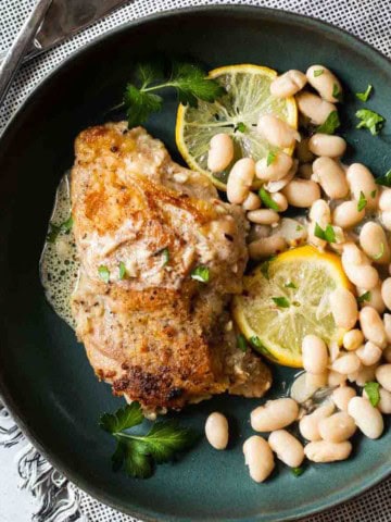 Pan fried chicken thighs served with lemon cream sauce and white beans.