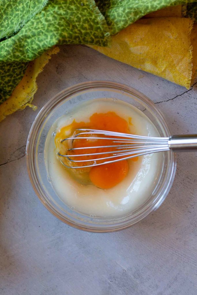 Whisking eggs with sugar to make homemade banana ice cream.
