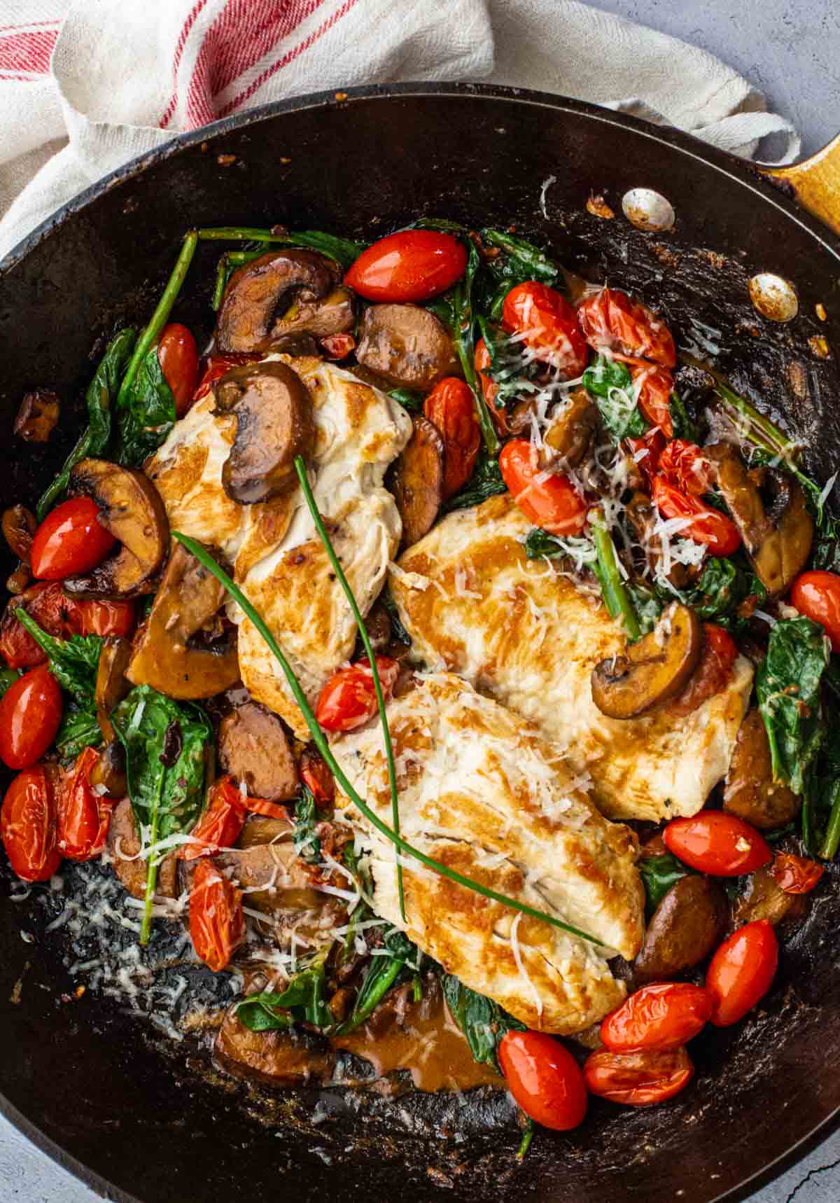 Chicken mushroom and spinach skillet with cherry tomatoes and parmesan.