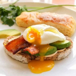 Open faced avocado and egg sandwich with bacon.