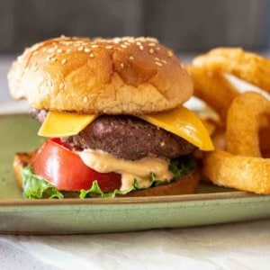 Steakhouse. burger with fry sauce, served with onion rings.