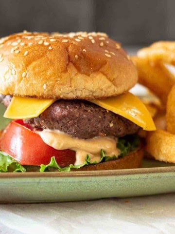 Steakhouse. burger with fry sauce, served with onion rings.