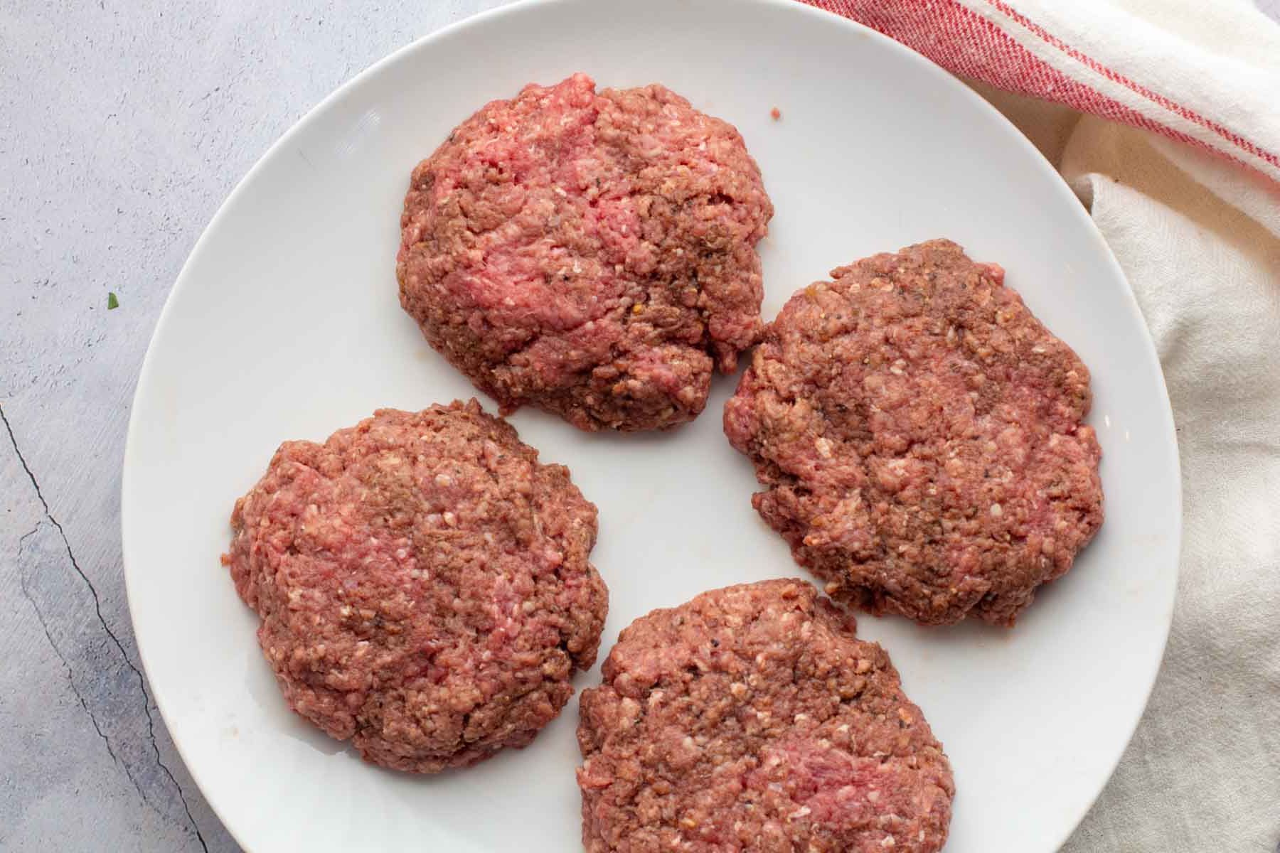 Steakhouse burger patties on a white plate.