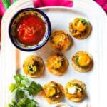 Air fryer nachos on a white Le Creuset platter served with salsa.