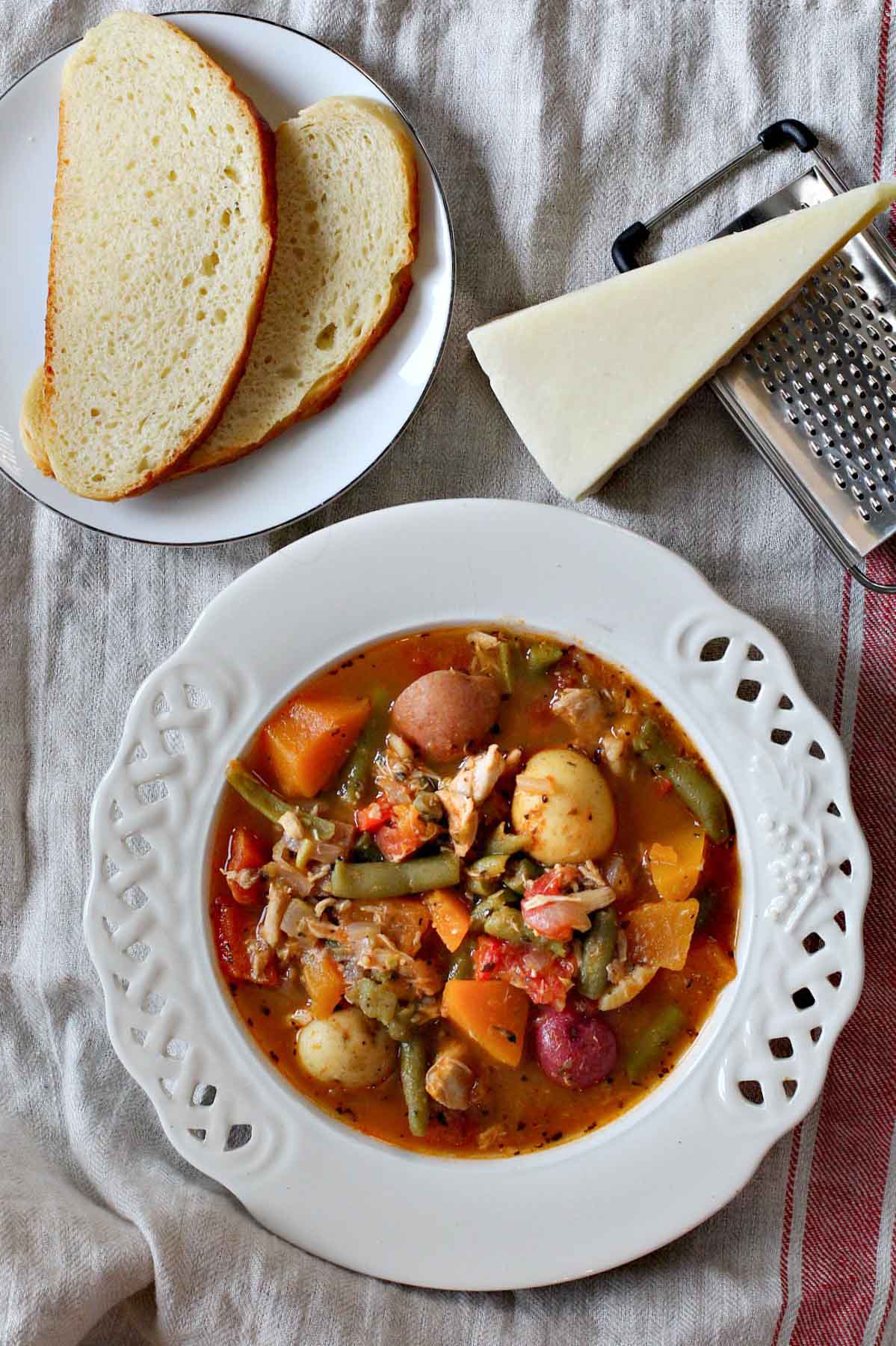 Potato soup with vegetables and white wine served with bread.