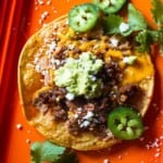 How to make a tostada with chorizo, refried beans and toppings.