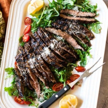 Beef Tagliata, thin sliced flank steak served over arugula and cherry tomatoes.
