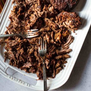 Shredded beef barbacoa on a white platter.