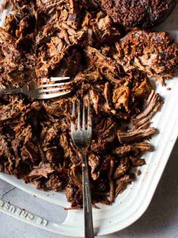 Shredded beef barbacoa on a white platter.