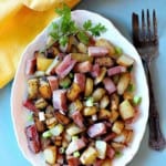 Fried ham and potaotes (country potatoes) on a white platter.