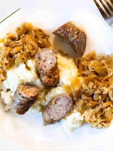 Caramelized kraut and brats served over mashed potatoes.
