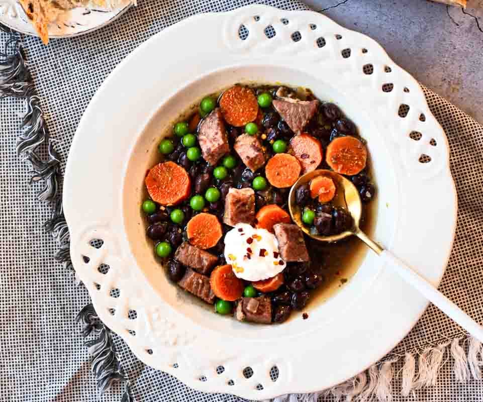 Ham and black bean soup served in a white bowl.