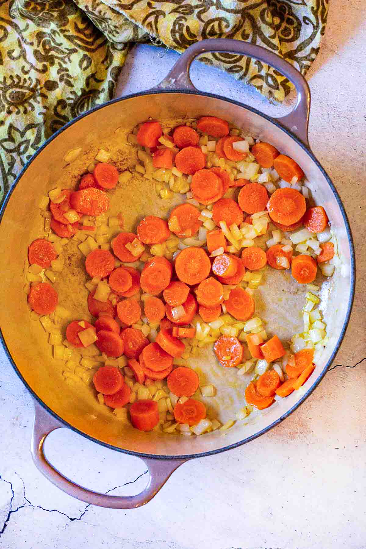 Sauteeing carrots and onions to make black bean soup with ham.