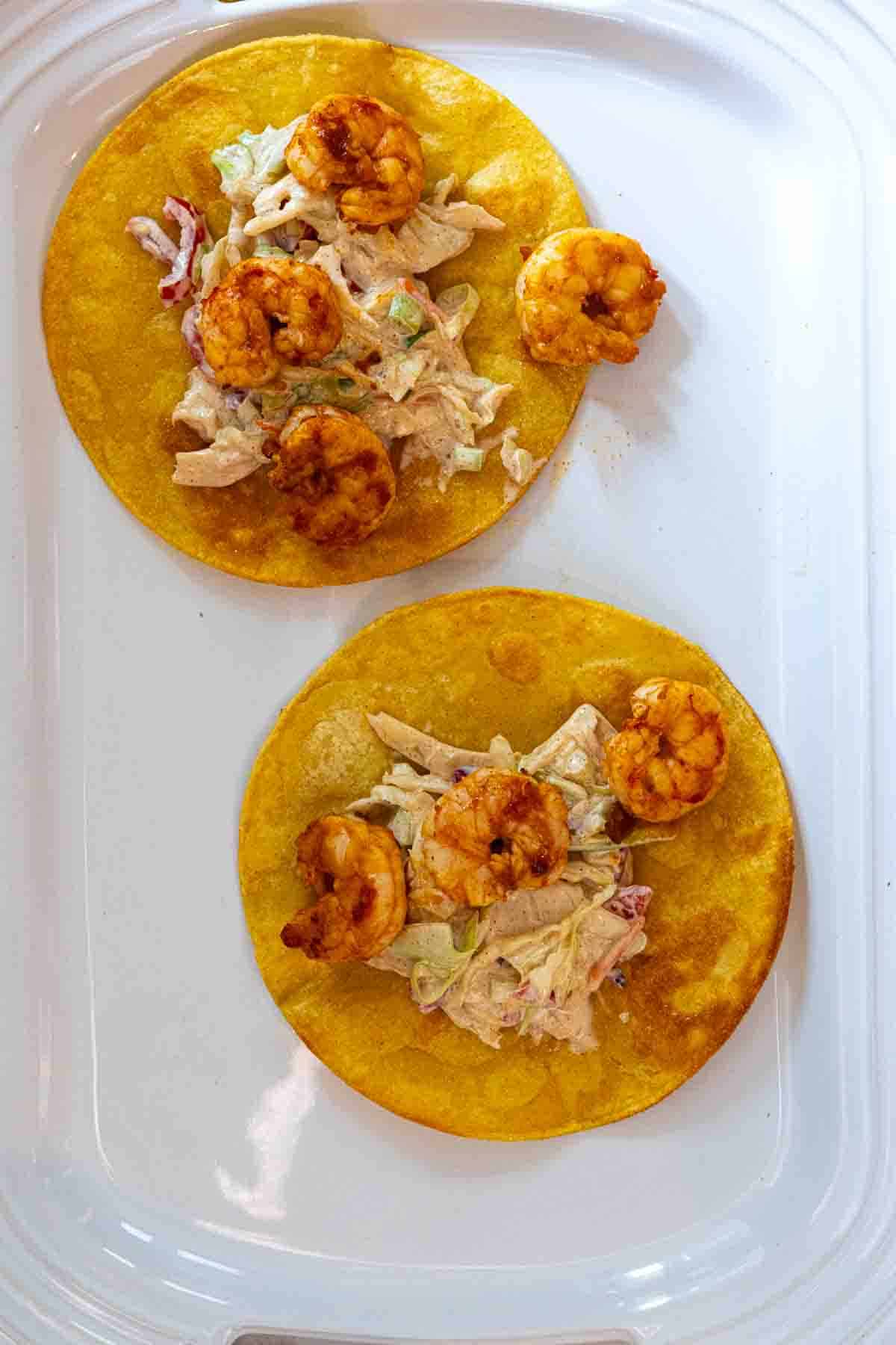 Adding adobo shrimp to tostadas to make shrimp tostadas, step 2.