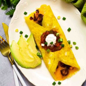 Chorizo omelette topped with salsa and sour cream.