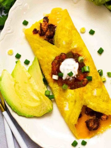 Chorizo omelette topped with salsa and sour cream.