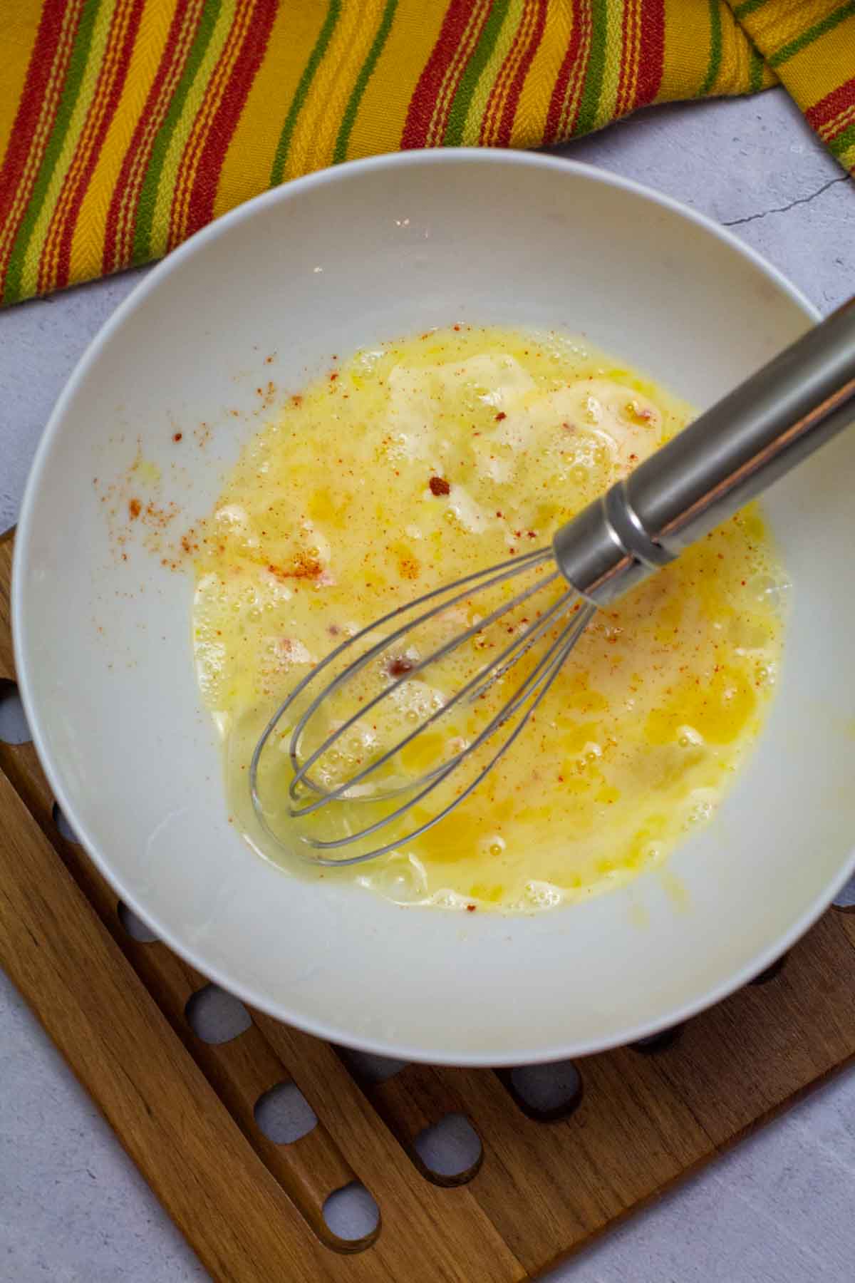 Mixing eggs with chile powder to make a Mexican Omelette,