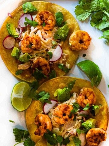 Shrimp tostadas with lime slaw and toppings.