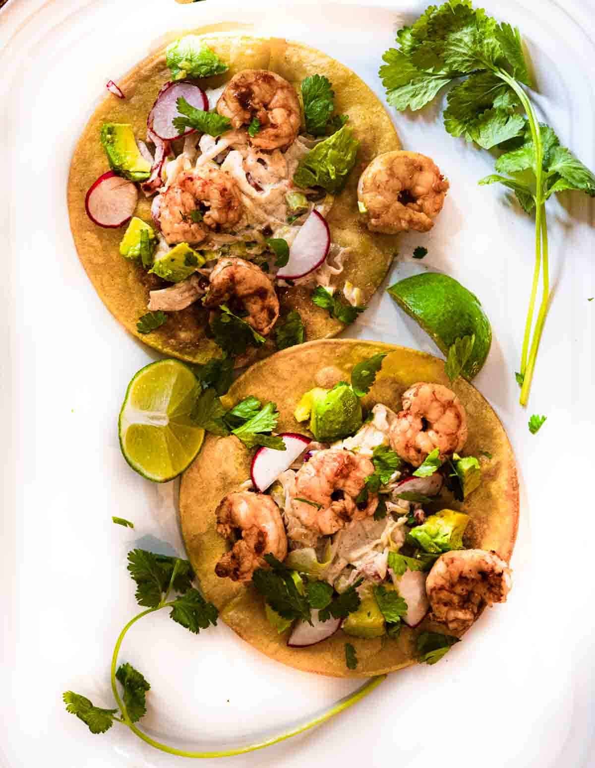 Shrimp tostadas with lime slaw topped with avocado, radish, cilantro.