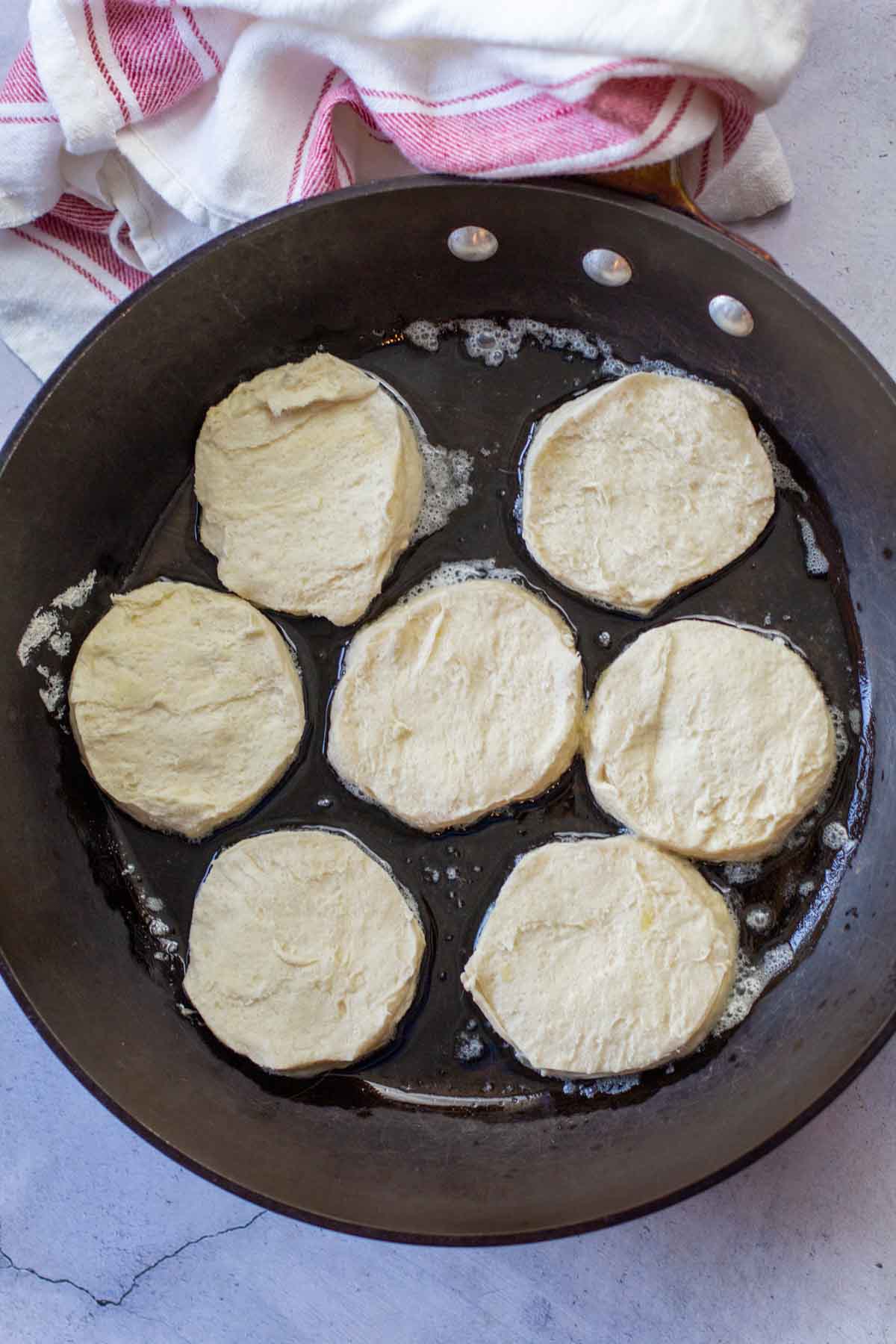 Frying canned biscuits in butter.