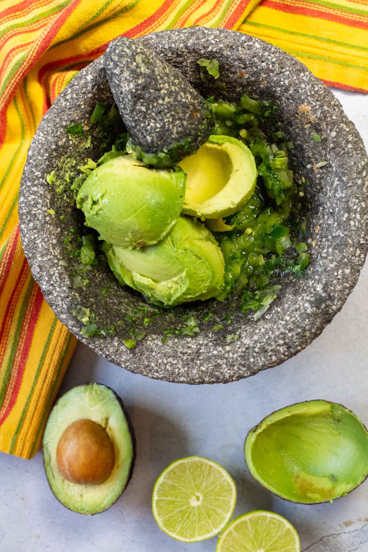 Making guacamole with a mortar and pestle.
