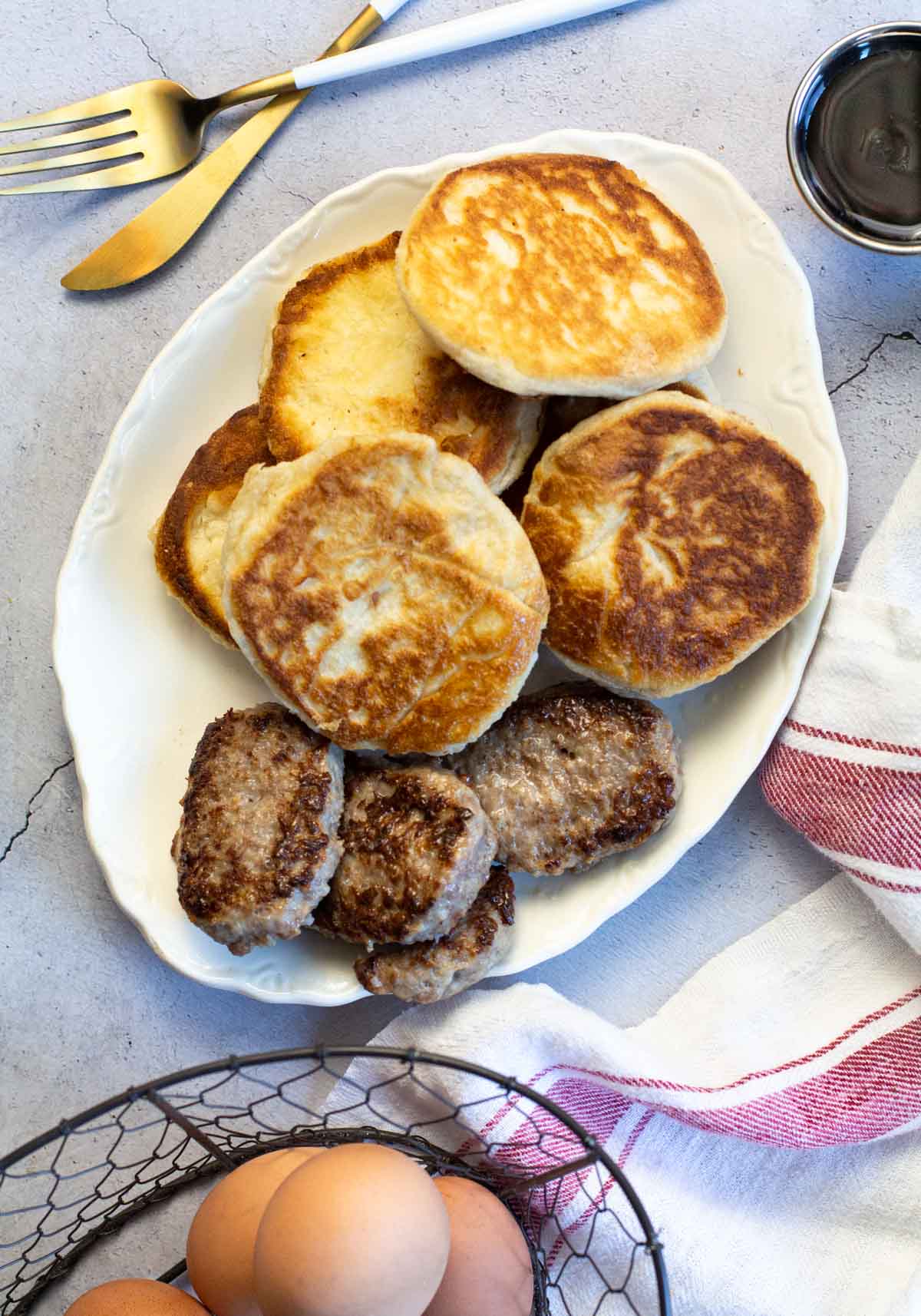 A platter of pan fried biscuits with sausage patties.
